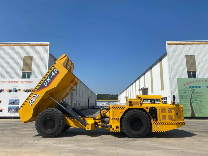 UK-40 underground haul truck with raised dump box displayed outside the factory, highlighting its 40-ton payload and articulated low-profile structure