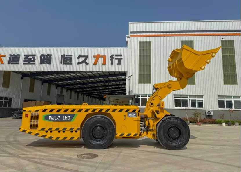 Side view of a yellow WJL-7 underground mining loader with a raised bucket